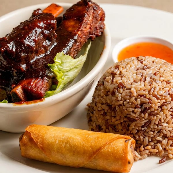 Glazed ribs, mixed rice, and an egg roll with dipping sauce on a white plate.
